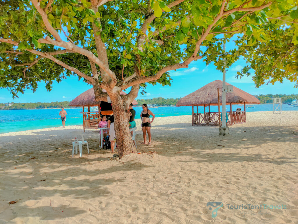 A view of the beach with cottages and people on it.